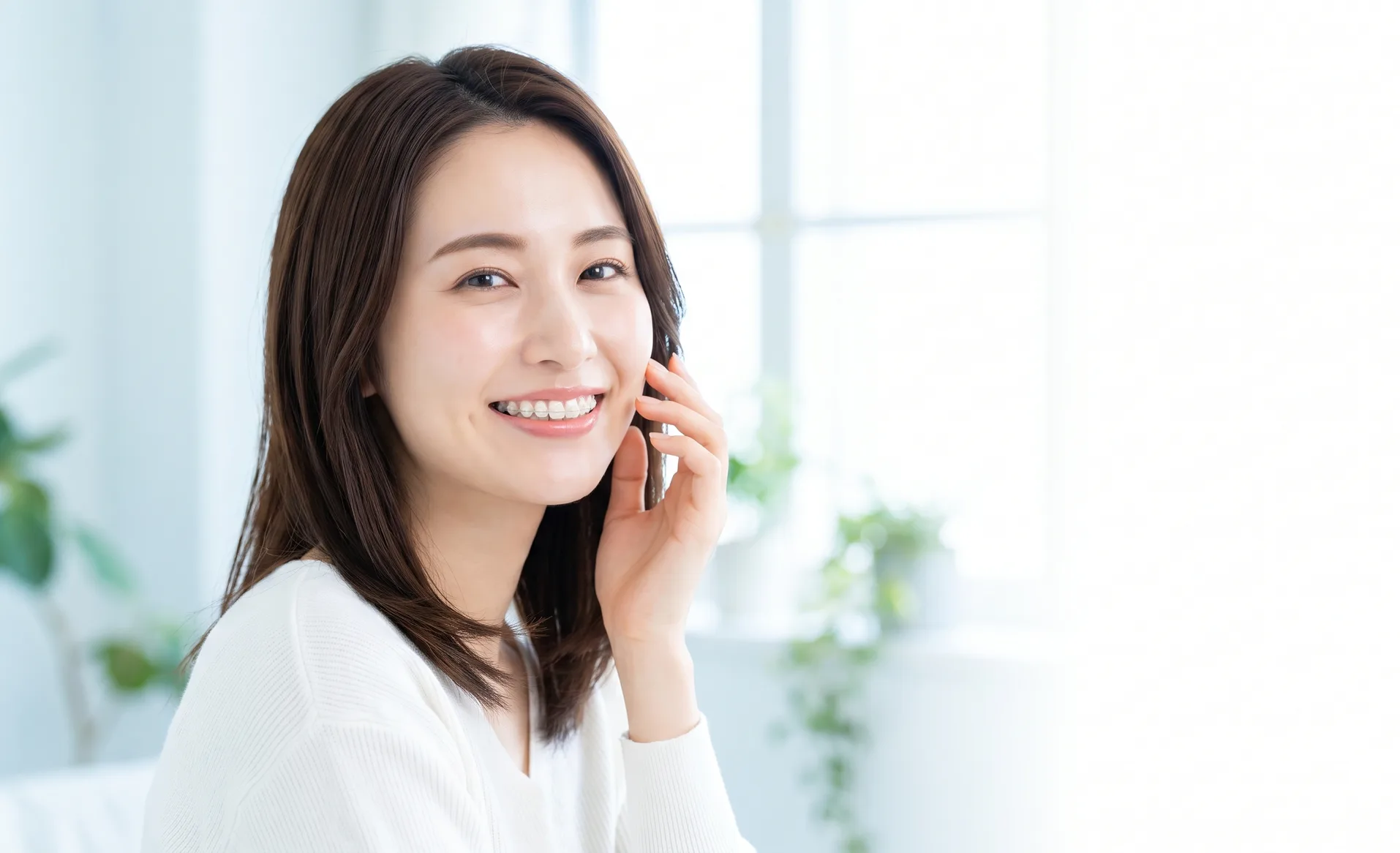 矯正装置を付けて笑顔の女性（イメージ）